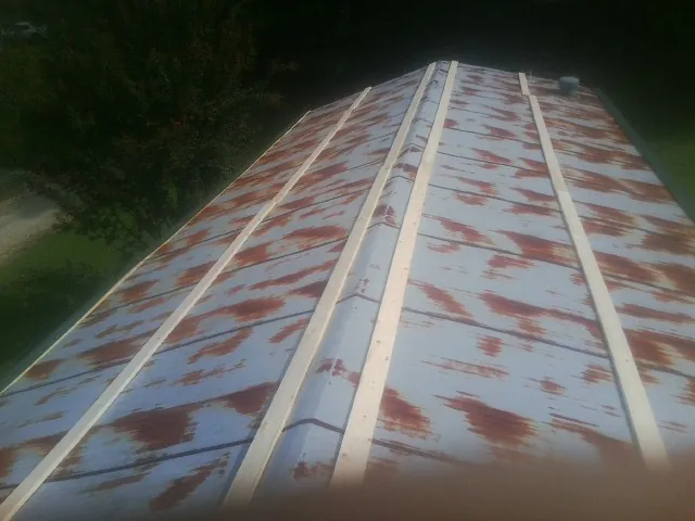 Rusted metal roof panels with new wood purlins before replacement — Storm Damage Roof Repair in Satsuma by Roofing Brothers
