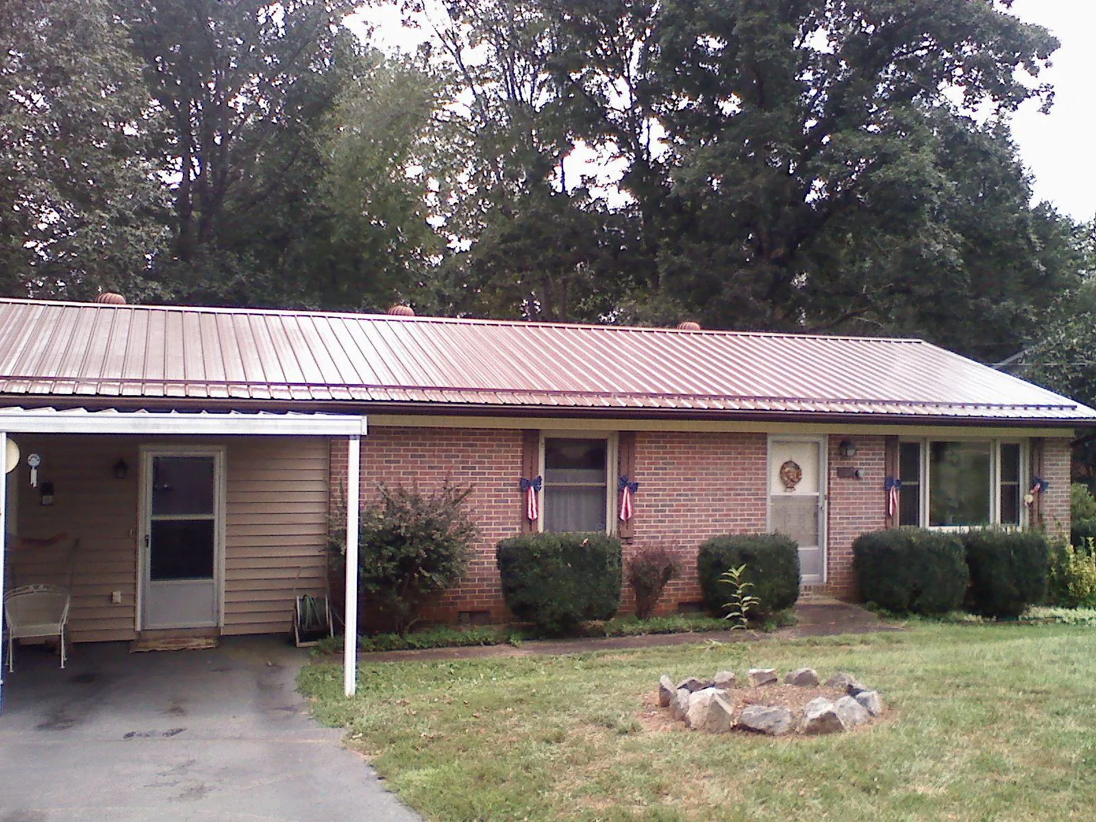 Bronze metal roof and carport on a brick ranch home — Roof Repair work by our crew in Satsuma