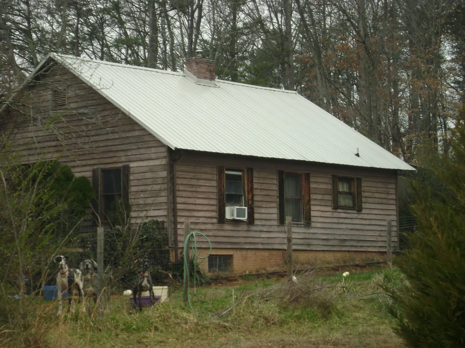 White metal roof on an old wood sided farmhouse, from a Metal Roof Installation job in Satsuma